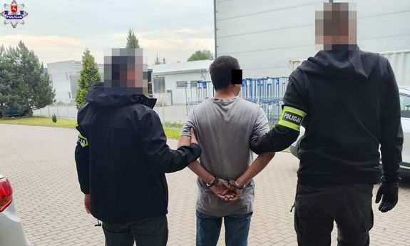 dwaj nieumundurowani policjanci prowadzą zatrzymanego - widok z tyłu.