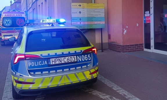 radiowóz zaparkowany przed wejściem do szpitala, w tle stoi karetka