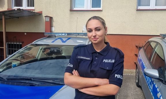 umundurowana policjantka stoi przed radiowozem