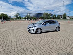 kierowca jadący samochodem osobowym z talerzem i piłką na masce podczas turnieju
