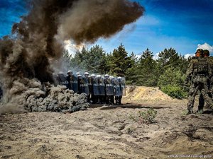 grupa funkcjonariuszy Policji podczas szkolenia z widoczną chmurą dymu