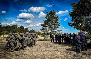 widoczne dwie grupy żołnierzy z tarczami oraz policjantów,  po przeciwnych stronach zdjęcia