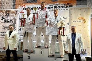 Karatecy na podium z dyplomami i pucharami