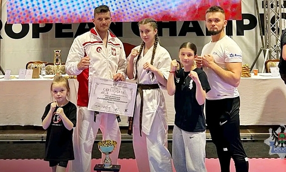 trzy dziewczyny i dwóch mężczyzn, zawodnicy karate, w pozują do zdjęcia