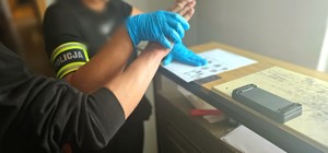 pobieranie odcisków palców od jednego z zatrzymanych
