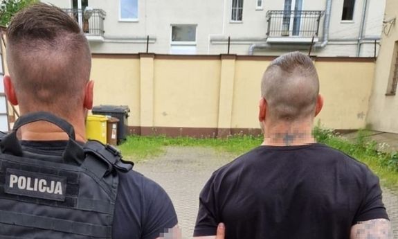 policjant idzie z zatrzymanym