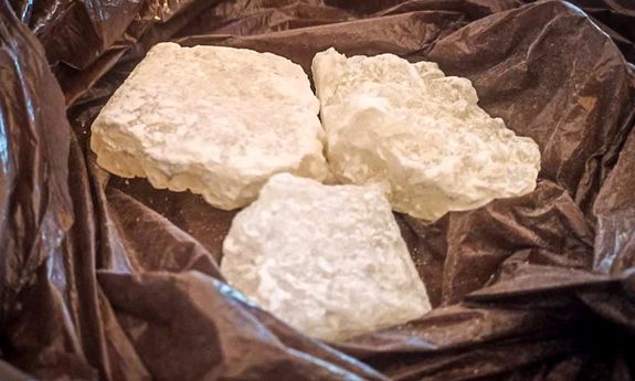 białe narkotyki leżą na brązowej foli