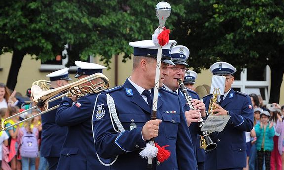 policjanci orkiestry reprezentacyjnej policji, z buławą oraz instrumentami w tle widoczne dzieci