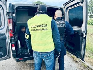 policjant i funkcjonariusz Straży granicznej przy radiowozie