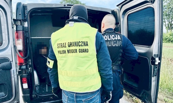 policjant i funkcjonariusz Straży granicznej przy radiowozie