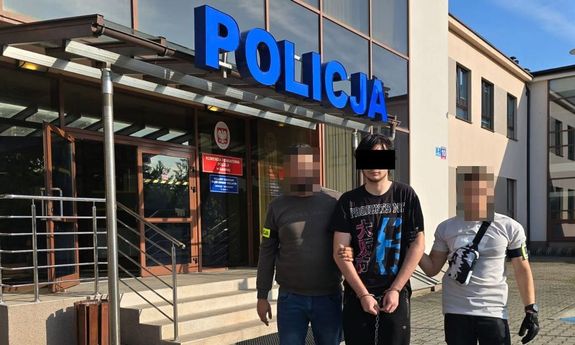 policjanci prowadzą zatrzymanego