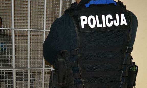policjant zamyka kraty celi