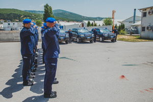 policjanci oddają hołd, w tle radiowozy
