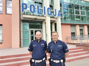 policjanci stoją przed budynkiem policji