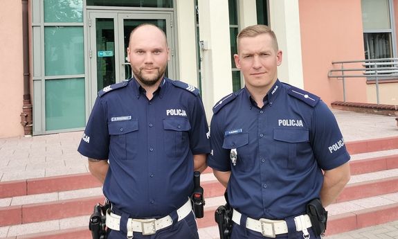 policjanci stoją przed budynkiem policji