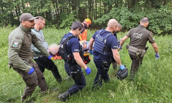 uczestniczący w poszukiwaniach niosą na noszach odnalezionego mężczyznę
