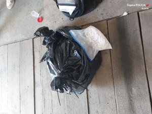 czarny worek plastikowy zamknięty trytytką oraz torebka strunowa z zawartością proszku koloru białego