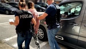 policjanci idą z zatrzymanym