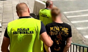 policjanci idą z zatrzymanym