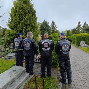 uczestnicy rajdu stoją przy grobie