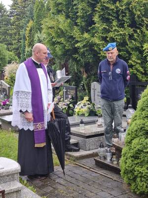 ksiądz i uczestnik rajdu na cmentarzu