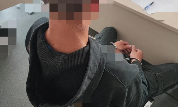 Zatrzymany siedzący na krześle podczas przesłuchania