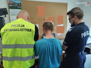 policjanci prowadzą zatrzymanego