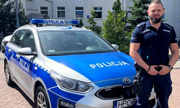 policjant, który uratował życie mężczyzny na tle budynku komendy i radiowozu oznakowanego