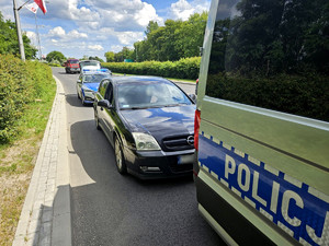 na zdjęciu zatrzymany pojazd stoi wzdłuż drogi i policyjne radiowozy