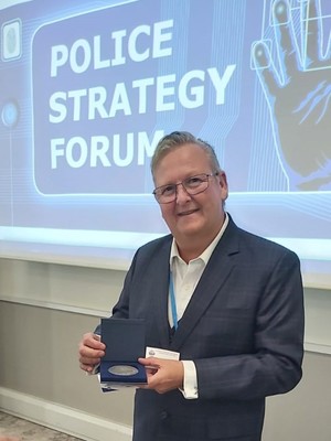 mężczyzna trzymający w ręku medal pamiątkowy w etui
