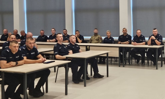 Policjanci podczas rozpoczęcia kursu. Policjanci siedzą w ławkach na auli OPP w Rzeszowie.