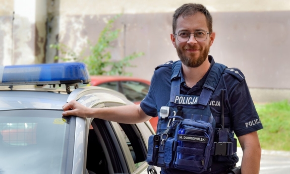 Asp. Maciej Dobrowolski przy radiowozie