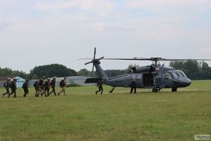 spadochroniarze idą na pokład szarego śmigłowca black hawk