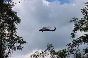 szary śmigłowiec black hawk pomiędzy drzewami