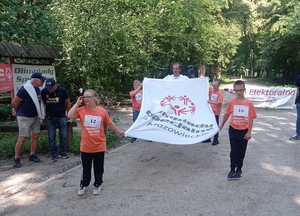dzieci niosą flagę z napisem olimpiady specjalne