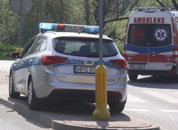 policyjny radiowóz, z tyłu widoczna karetka pogotowia ratunkowego