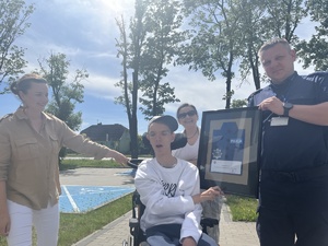 chłopiec otrzymuje od policjanta upominek