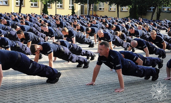 policjanci wykonują pompki na placu