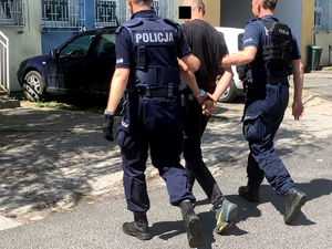 policjanci prowadzą zatrzymanego do budynku policji