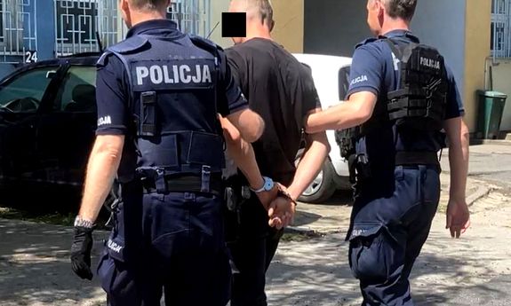 policjanci prowadzą zatrzymanego do budynku policji