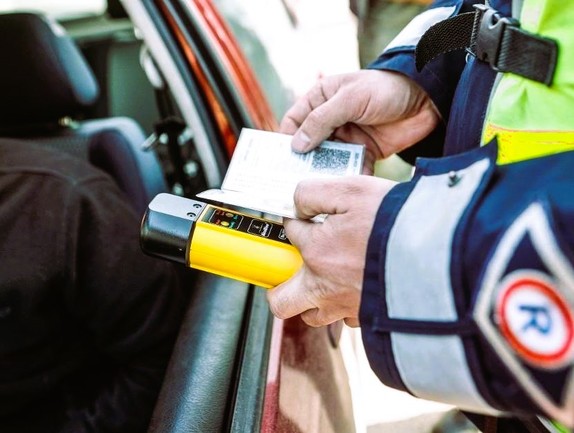 dłonie policjanta, w których trzyma alcoblow