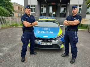 policjanci stoją na tle radiowozu