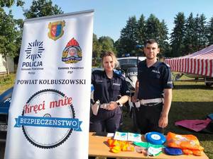 Para policjantów pozuje do zdjęcia przy stoisku profilaktycznym.