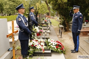 dwaj policjanci na warcie honorowej przy grobie generała Papały, naprzeciwko nich stoi nadinspektor Roman Kuster oddając hołd