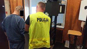 policjant pobiera odciski palców od zatrzymanego mężczyzny