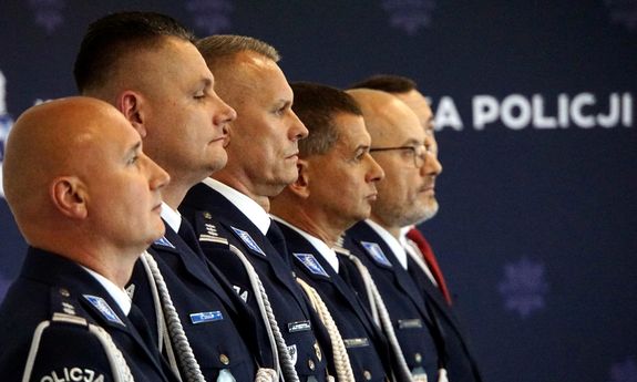 funkcjonariusze policji w mundurach na tle granatowego tła
