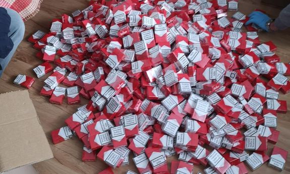 papierosy w biało czerwonych opakowaniach rozsypane na  podłodze