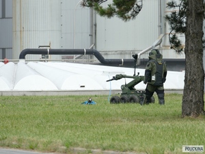 policjant w stroju pirotechnika stoi za robotem pirotechnicznym