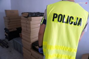 policjant tyłem przed nielegalnymi papierosami