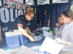 Dwie policjantki z dziećmi w namiocie profilaktycznym.